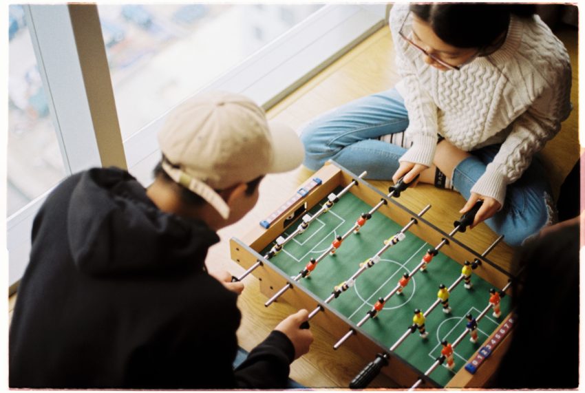 young adults playing foosball